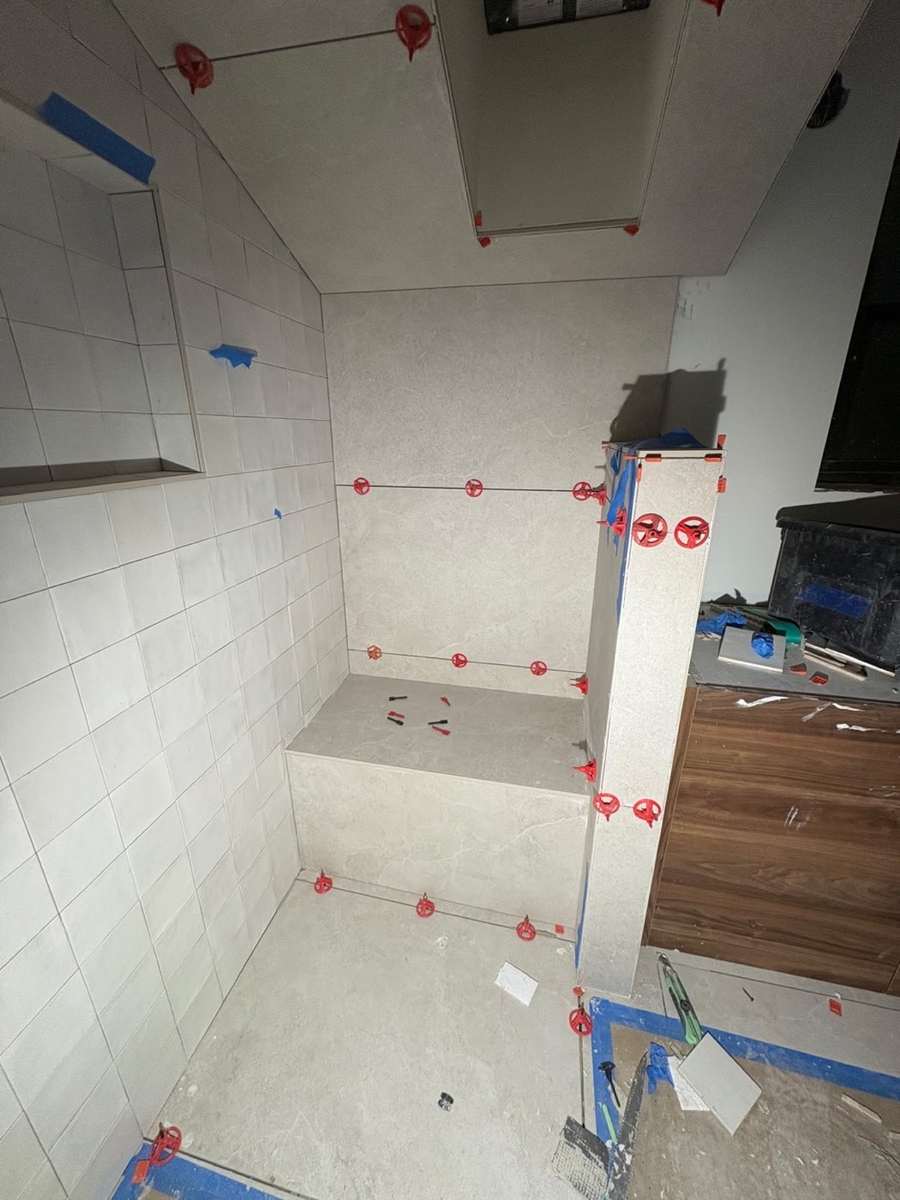 Large-format bathroom tile installation in progress