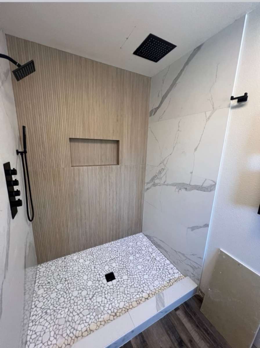 Finished custom shower with large-format tile and matte black fixtures