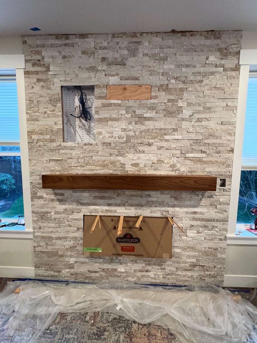 Stone fireplace surround and floating mantel during installation